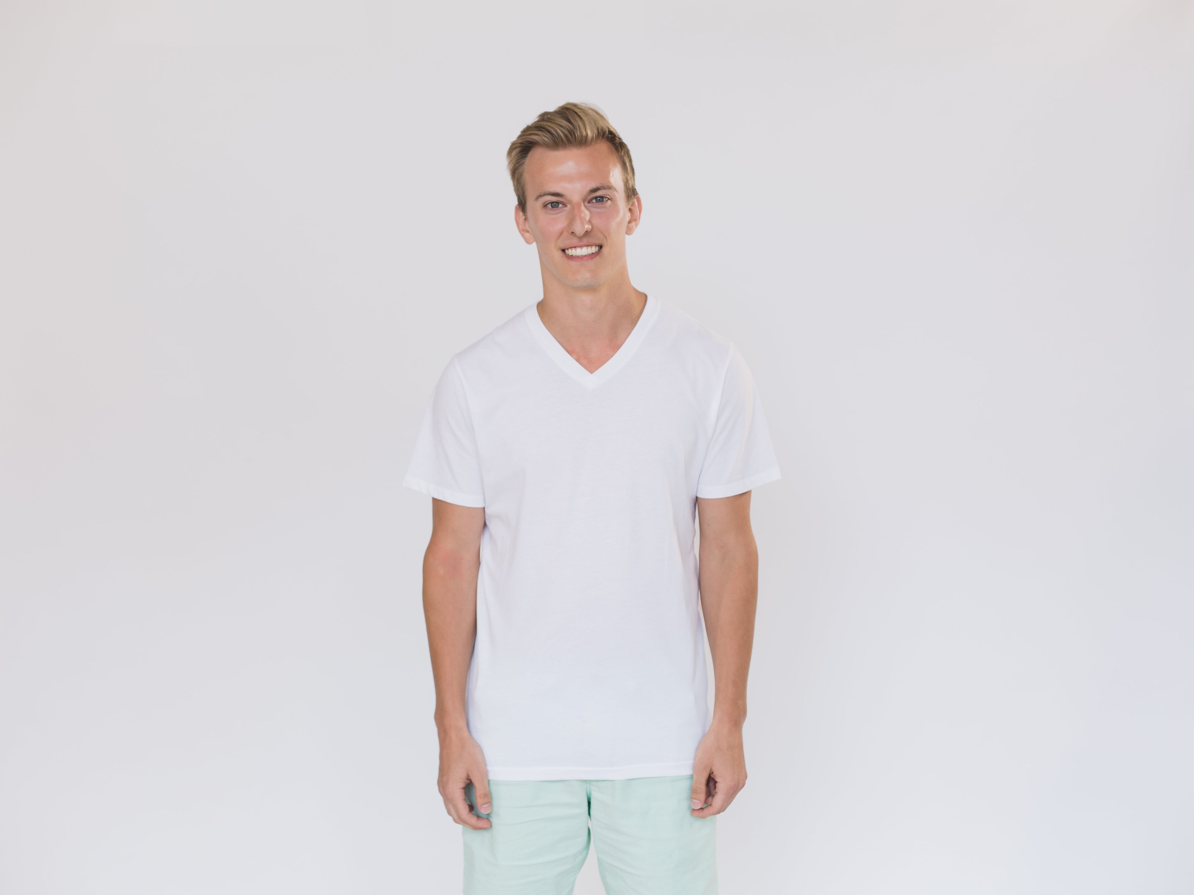 Model wearing a plain white V-neck cotton t-shirt against a light background